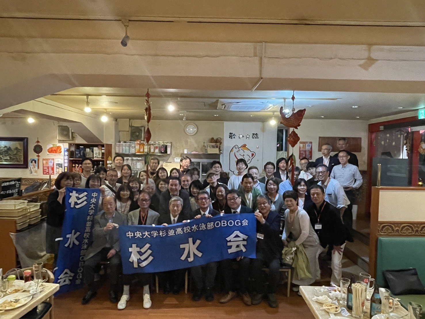 記念懇親会で杉水会の旗を持つ参加者の集合写真